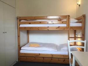 2 Etagenbetten in einem Zimmer mit einem Tisch in der Unterkunft Haus Bernstein Ferienwohnungen in Göhren