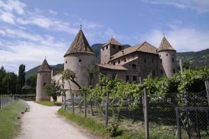 un gran castillo con una valla delante en Andreas Hofer Residence, en Bolzano
