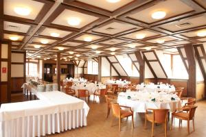 a dining room with tables and chairs with white linens at Hotel Restaurant zur Linde in Pattensen