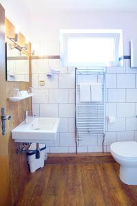 a white bathroom with a sink and a toilet at Hotel Restaurant zur Linde in Pattensen