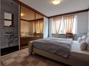 a bedroom with a large bed and a bathroom at Hotel Happy in Bad Bramstedt