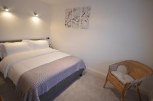 a bedroom with a bed and a wicker chair at 4A Soho Studios 4th floor by Indigo Flats in London