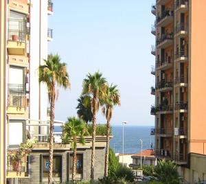 カターニアにあるLa Casa di Luigiのヤシの木と海の景色を望む建物