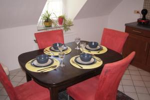 a dining room table with red chairs and a black table with glasses at Lillie 3-4 Personen - Ferienwohnungen Wagner & Gaul Falkenauel in Falkenauel