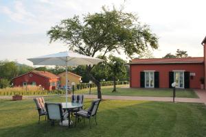 a table and chairs with an umbrella in a yard at Residence Casali Romei in Sarzana