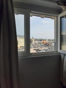 a window in a room with a view of a city at Les Embruns in Trouville-sur-Mer
