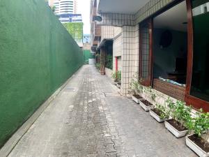 eine leere Gasse mit Pflanzen an der Seite eines Gebäudes in der Unterkunft Abrolhos Praia Hotel in Fortaleza