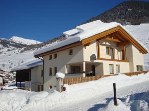 een huis bedekt met sneeuw voor een berg bij Ferienwohnung Abraham in Nauders