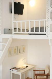 a white room with a desk and a tv at The Pulse Residence Astypalea in Astypalaia