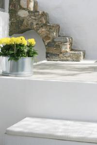 a bucket of yellow flowers sitting on top of a counter at The Pulse Residence Astypalea in Astypalaia +29 photos