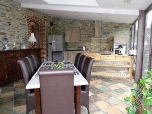 uma cozinha com mesa e cadeiras num quarto em Gîte La Détente Gourmande - Porcheresse em Daverdisse