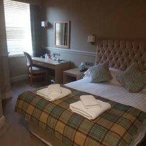 a bedroom with a bed with two towels on it at Fox and Pheasant Inn in Armathwaite