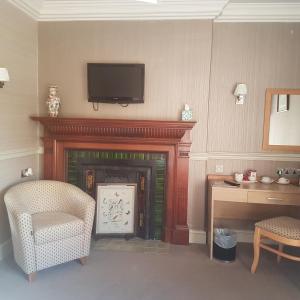 a living room with a fireplace with a television above it at Fox and Pheasant Inn in Armathwaite