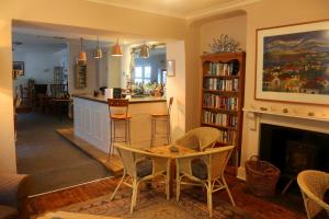 a living room with a table and a fireplace at Penryn House Hotel in Polperro