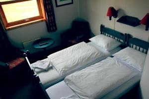 two twin beds in a bedroom with a window at Nordkapp Camping in Honningsvåg +32 photos