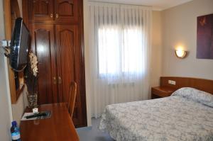 a bedroom with a bed and a table with a television at La Chopera in Ribadesella +42 photos