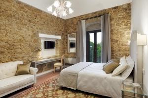 a bedroom with a king sized bed and a couch at Itria Palace in Ragusa