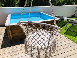 een mandschommel op een terras met een zwembad bij Les Terrasses in Lavérune +13 foto's