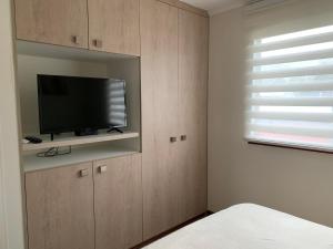 a bedroom with a flat screen tv on a wall at Casa Condominio Los Robles II in Pucón