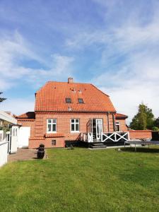 欧登塞H. C. Lumbyes Vej - kælderlejlighed的一座带橙色屋顶的大型砖屋