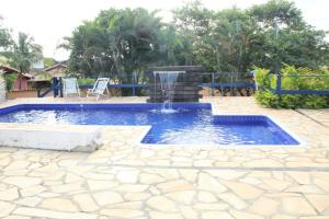 a pool with a water fountain in a yard at Pousada da Serra in Serra do Cipo