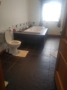 a bathroom with a toilet and a bath tub at Valhalla B&B in Bowermadden