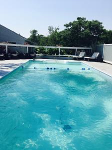 a large swimming pool with blue water at The Drake Inn in Hampton Bays