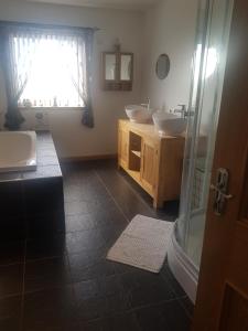a bathroom with two sinks and a shower at Valhalla B&B in Bowermadden
