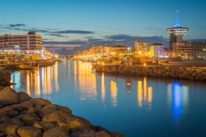 a view of a river with buildings at night at Grand appartement Le Prado avec terrasse in Montpellier +17 photos