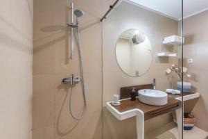 a bathroom with a shower with a sink and a mirror at Art & Design Apartment in Porto
