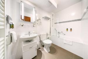 a white bathroom with a toilet and a sink at Bellevue Hotel Český Krumlov in Český Krumlov