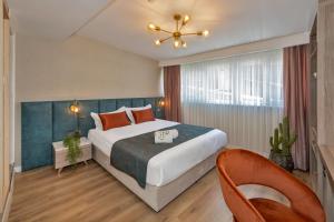 Una habitación de hotel con una cama grande y una silla. en Nika otel & cafe, en Estambul