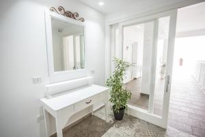 Baño blanco con lavabo y espejo en Aras Hotel Boutique, en Villasimius
