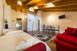 1 dormitorio con cama, sofá rojo y mesa en Dimore Verona Residenza Zeno, en Verona