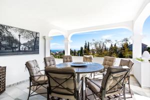 una sala da pranzo con tavolo e sedie di Luxury Villa Marbella with nice garden, Pool and Jacuzzi BY Varenso Holidays a Marbella