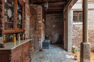 a kitchen with brick walls and a stone floor at B&B Casin dei Nobili in Venice