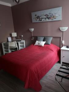 a red bed with a red blanket in a bedroom at Les Glycines in Le Vigan