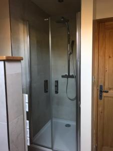 a shower with a glass door in a bathroom at Le Dosne in Saint-Didier-sur-Arroux