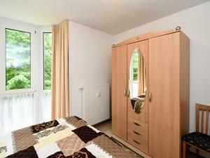 a bedroom with a wooden cabinet and a bed at Ferienwohnung 8-3 in Baabe