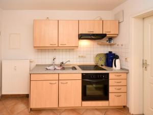 a kitchen with wooden cabinets and a sink at Ferienwohnung 8-3 in Baabe