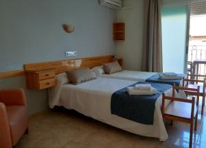 a bedroom with two beds and a table and chairs at Hotel Alaska in Lo Pagán