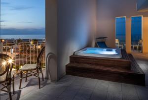 a room with a bath tub on a balcony at Hotel Ambassador in Rimini