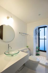 a bathroom with a sink and a toilet and a mirror at Trat 101 Hotel - SHA Certified in Trat