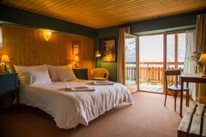 Un dormitorio con una cama grande y un balcón. en Plein Ciel - Hôtel d'altitude à 1800m, en Champéry
