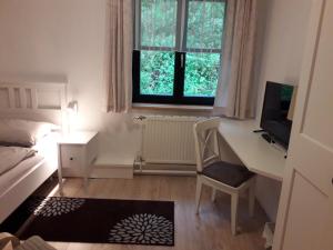 Schlafzimmer mit einem Schreibtisch, einem Bett und einem Computer in der Unterkunft Pension Hendling in Klingfurth