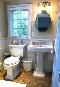 a bathroom with a toilet and a sink and a mirror at Revere Guest House in Provincetown