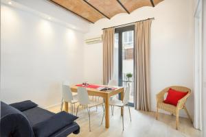 a dining room with a table and chairs and a couch at BcnStop Parc Güell in Barcelona