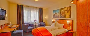 Cette chambre comprend un lit et un bureau. dans l'établissement Trip Inn Hotel Zum Riesen Hanau, à Hanau