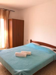 a bedroom with a bed with two towels on it at Family Rooms in Ulcinj