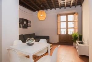 een woonkamer met een witte tafel en stoelen bij Apartamentos Nahira Suites 3000 in Granada